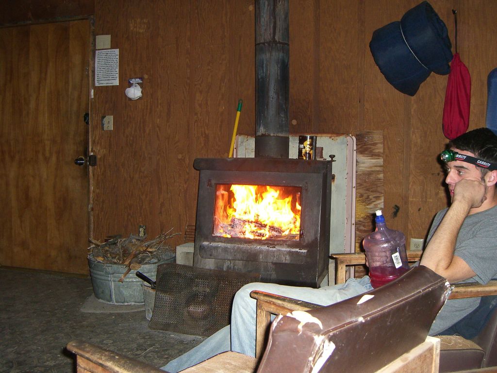 The wood burning stove is great to have on cold nights.  In this picture, Ryan is keeping warm by the fire.  New park regulations as of 2014 do not allow for fires inside of cabins: