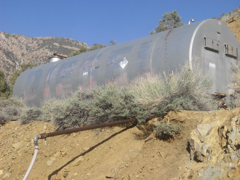 A giant diesel tank sitting up on the bank, providing the fuel once used to keep this place running: