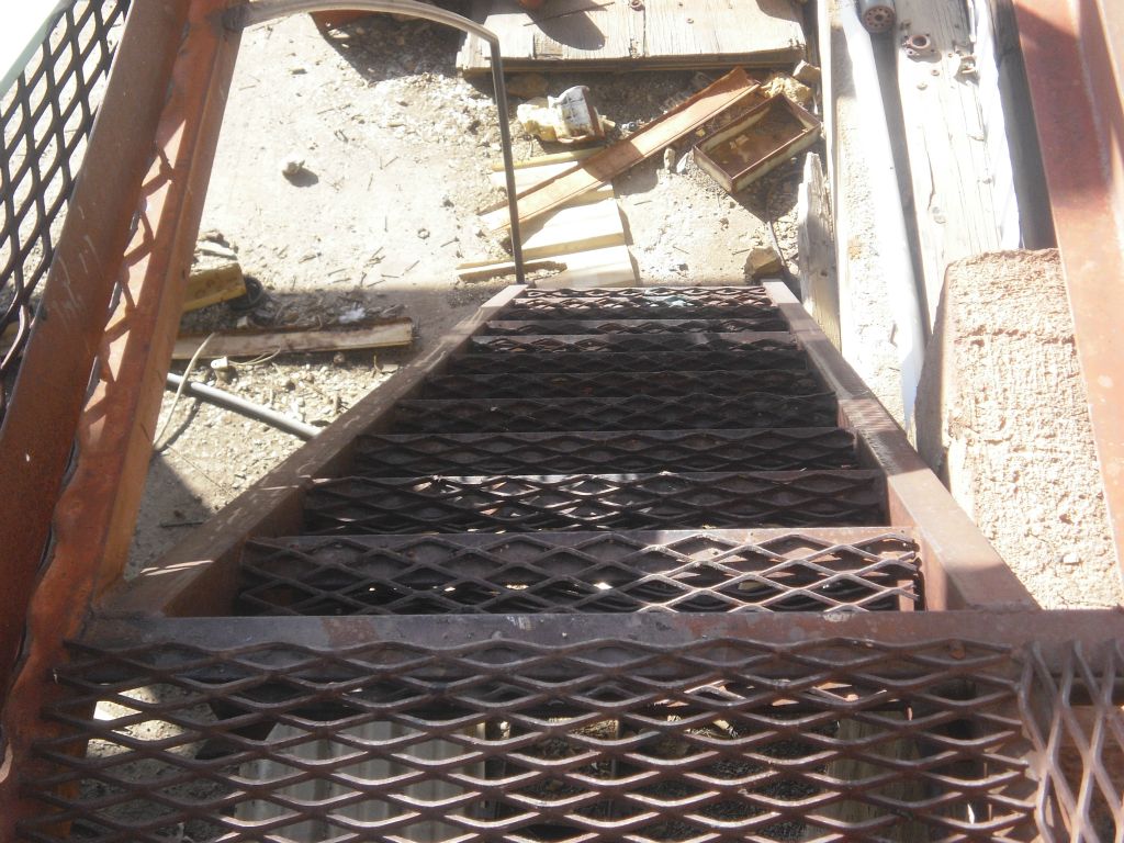 An iron stairwell leads down to the lower story in this building: