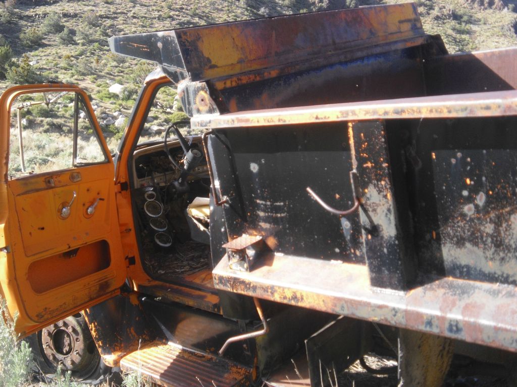 This old truck is resting near the buildings in the center of town:
