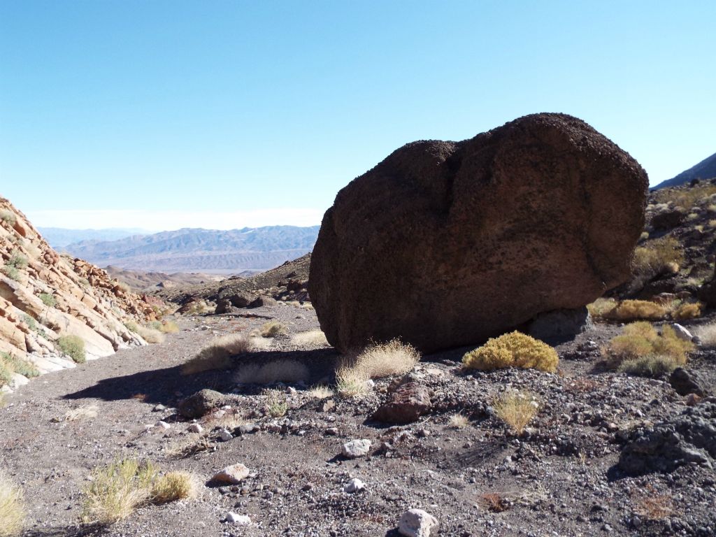 Dropping into the wash and looking back at a massive boulder: