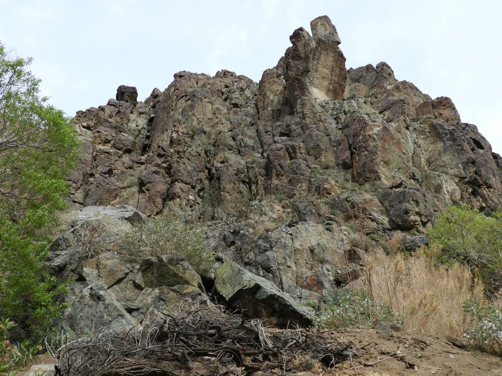 Looking up at an impressive solid rock hillside with the potential for future rock fall: