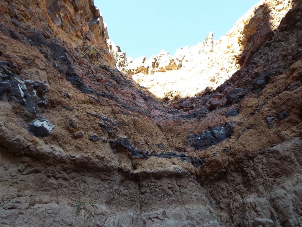 Looking straight up at the layered dry fall from within the plunge pool: