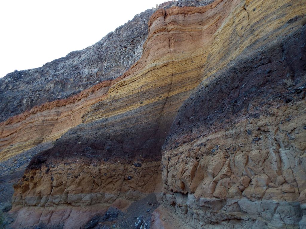 Continuing along and looking up as the colorful layers stand out despite erosion impacting the wall in the next two pictures: