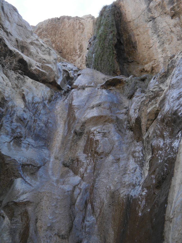 The upper portion has a mossy drop, while the lower portion is just water flowing over slick rock: