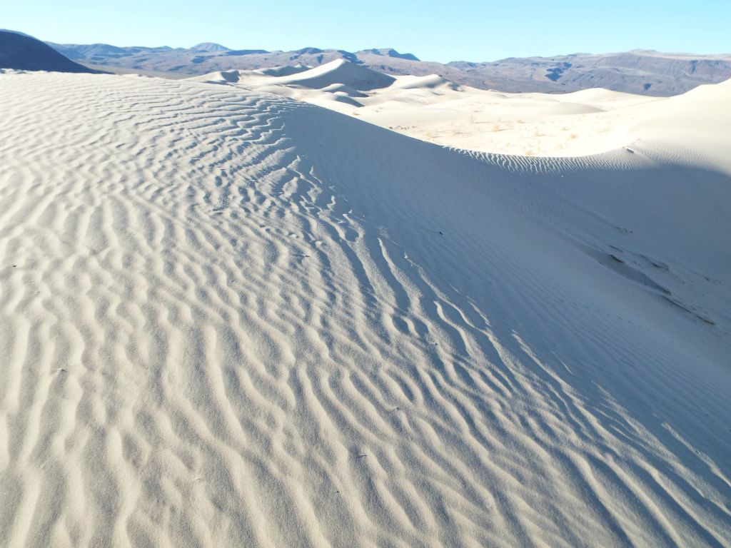 A slight variation in the sand patterns perhaps caused by a small amount of wind blowing through: