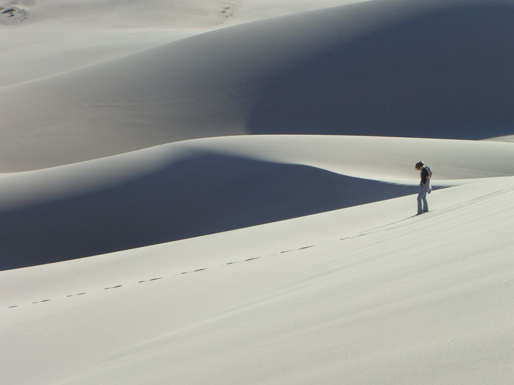 Tiffany looking down at the tracks she has created in the sand: