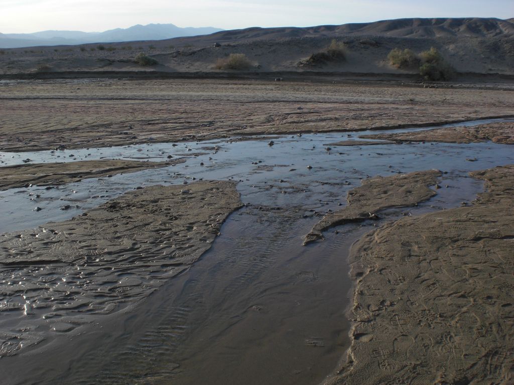 Crossing the flowing creek in order to hike through the hills on the other side: