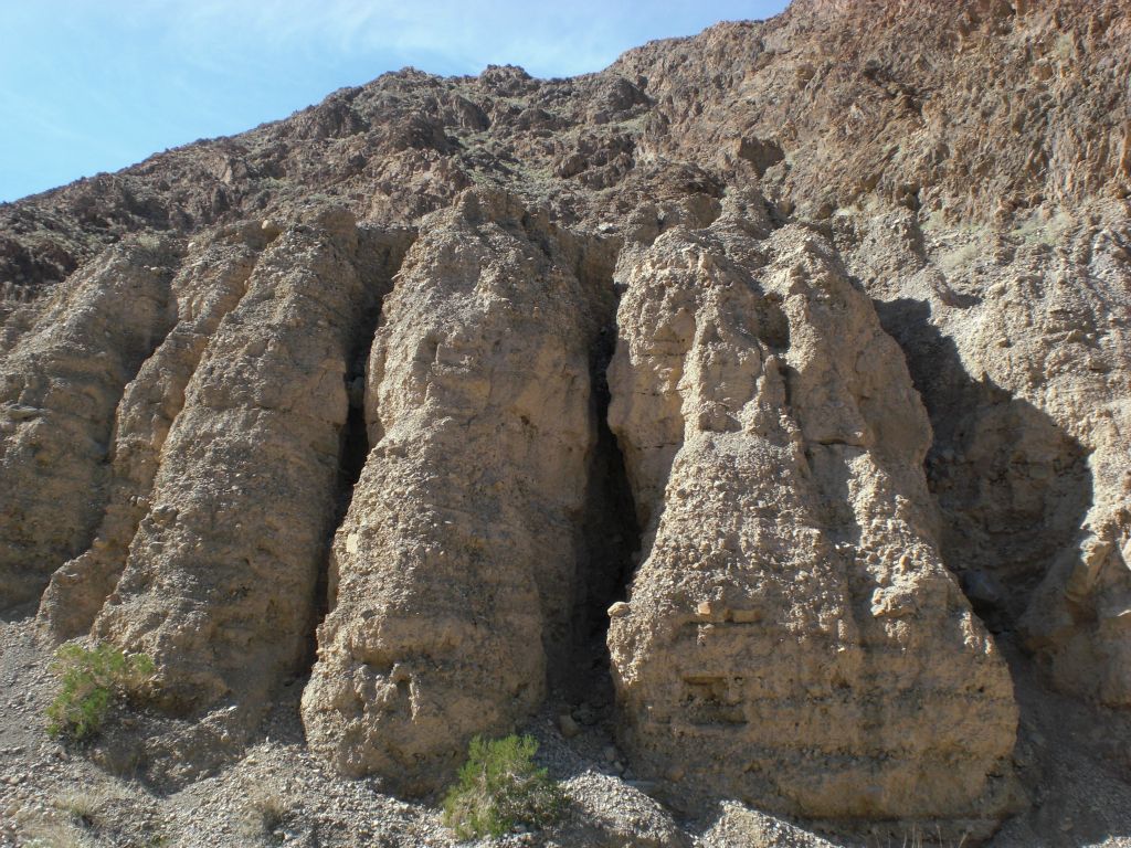 Miniature slots cutting into the dirt hillside and formations:
